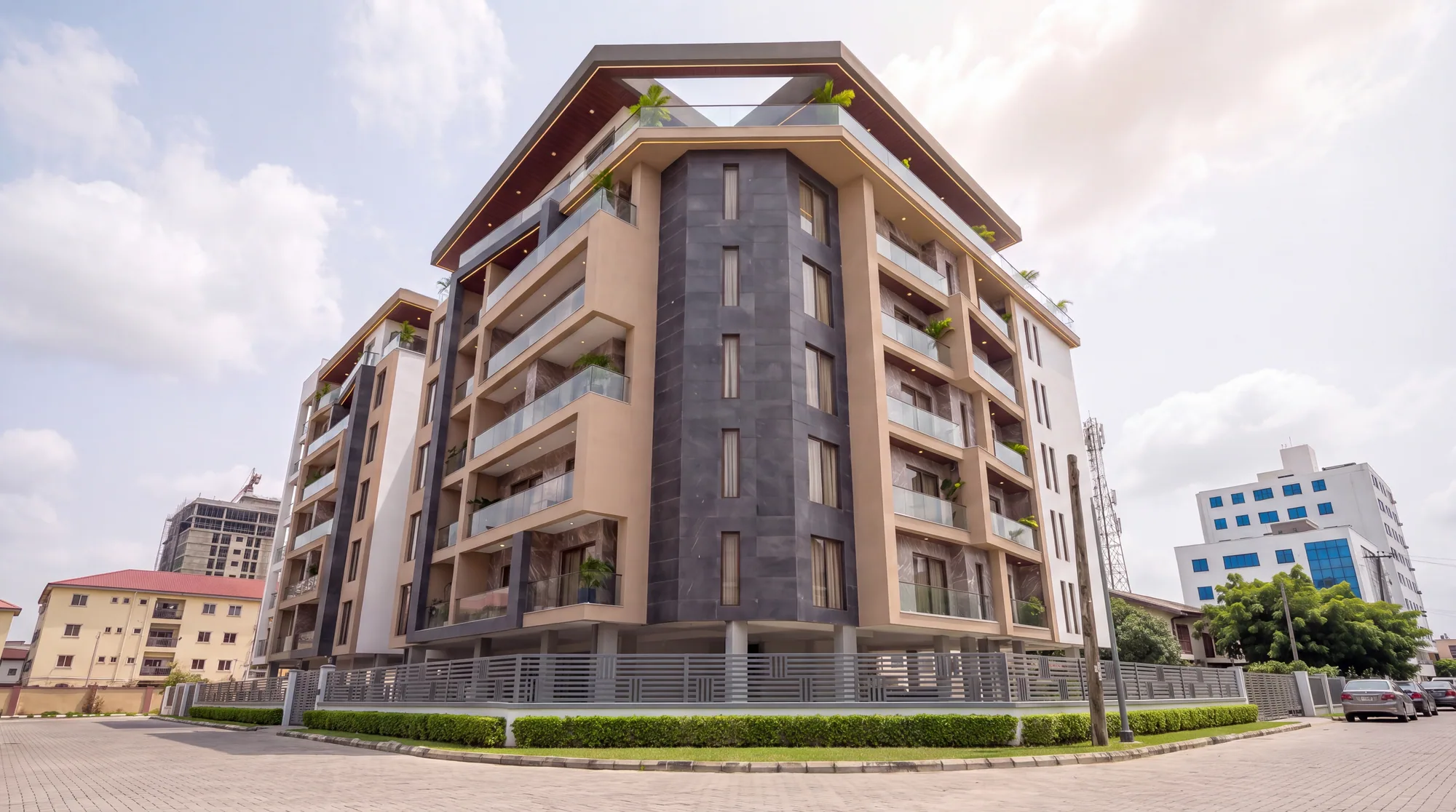 Low view of The Quorum from the street corner, dark stone tower between beige balcony frames